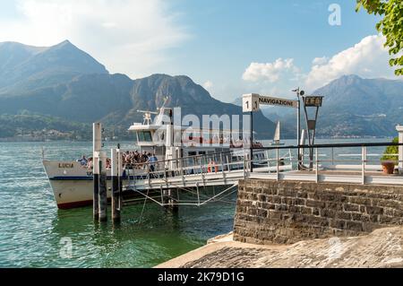 Bellagio, Lombardei, Italien - 5. September 2022: Die Fähre mit Touristen am Pier des malerischen Dorfes Bellagio am Comer See. Stockfoto