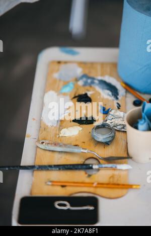 Nahaufnahme der Palette des Malers mit Werkzeugen auf dem Tisch Stockfoto