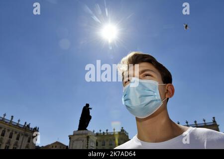 ©PHOTOPQR/L'EST REPUBLICAIN/ALEXANDRE MARCHI ; NANCY ; 05/08/2020 ; SANTE - CRISE SANITAIRE - EPIDEMIIE DE COVID 19 - CORONAVIRUS - ARRETE PREFECTORAL - PORT DU MASQUE OBLIGATOIRE - SCHUTZ - MASQUE CHIRURGICAL - CHALEUR - METEOROLOGIE - METEO - CANICULE - TEMPERATUR - CIEL BLEU - SOLEIL - ABEILLE. Nancy 5 août 2020. Une personne porte un masque chirurgical de Protection, dans le Centre ville de Nancy, sur la Place Stanislas. après avoir constaté 'une Augmentation du taux d'Incidence de Covid-19 sur le territoire de la Métropole du Grand Nancy' par les autorités sanitaires, le préfet de me Stockfoto