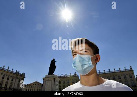 ©PHOTOPQR/L'EST REPUBLICAIN/ALEXANDRE MARCHI ; NANCY ; 05/08/2020 ; SANTE - CRISE SANITAIRE - EPIDEMIIE DE COVID 19 - CORONAVIRUS - ARRETE PREFECTORAL - PORT DU MASQUE OBLIGATOIRE - SCHUTZ - MASQUE CHIRURGICAL - CHALEUR - METEOROLOGIE - METEO - CANICULE - TEMPERATUR - CIEL BLEU - SOLEIL. Nancy 5 août 2020. Une personne porte un masque chirurgical de Protection, dans le Centre ville de Nancy, sur la Place Stanislas. après avoir constaté 'une Augmentation du taux d'Incidence de Covid-19 sur le territoire de la Métropole du Grand Nancy' par les autorités sanitaires, le préfet de Meurthe-et-M Stockfoto