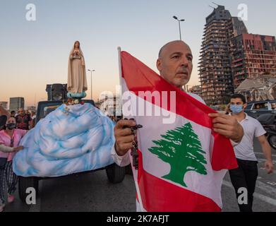 ©CAROLINE BLUMBERG/MAXPPP - Ein Auto mit einer Statue der Jungfrau Maria fährt nach der Explosion im Hafen von Beirut während einer Prozession zum Fest der Himmelfahrt Mariens in Beirut, Libanon, am 15. August 2020 vor das beschädigte Gebäude in der Nähe des verwüsteten Hafengebiets. Nach Angaben des libanesischen Gesundheitsministeriums wurden bei der Explosion in Beirut, die am 04. August das Hafengebiet zerstörte und vermutlich durch geschätzte 2.750 Tonnen Ammoniumnitrat in einem Lagerhaus verursacht wurde, mindestens 179 Menschen getötet und mehr als 6.000 verletzt, wobei 49 Menschen vermisst wurden. Stockfoto