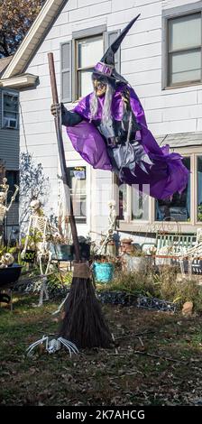 Eine fliegende Hexe mit ihrem Besenstiel, einer Spinne und Skeletten bei einer Halloween-Ausstellung in Osceola, Wisconsin, USA. Stockfoto