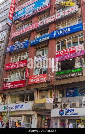 ISTANBUL, TÜRKEI - 22. JULI 2019: Verschiedene Anzeigen an einem Gebäude in Bahcelievler Nachbarschaft in Istanbul, Türkei Stockfoto