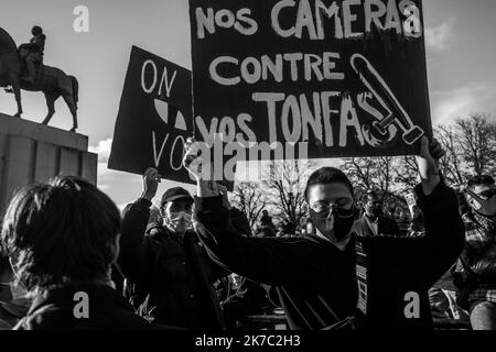 ©Michael Bunel / Le Pictorium/MAXPPP - Michael Bunel / Le Pictorium - 21/11/2020 - Frankreich / Ile-de-France / Paris - Deux manifest portent des pancartes avec ecrit, nos cameras contre vos tonfas.10 000 personnes se sont rassemblees place du Trocadero pour protester contre la loi securite globale (loi Darmanin). La loi cherche notammment a Limiter la captation en image des Policiers en Service. 21. November 2020. Paris, Frankreich. / 21/11/2020 - Frankreich / Ile-de-France (Region) / Paris - zwei Demonstranten tragen Plakate mit Aufschriften, unsere Kameras gegen Ihre Tonfas. 10.000 Menschen versammelten sich Stockfoto