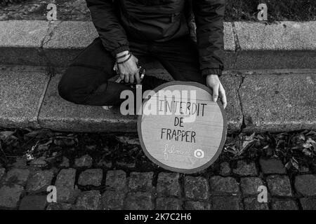 ©Michael Bunel / Le Pictorium/MAXPPP - Michael Bunel / Le Pictorium - 21/11/2020 - Frankreich / Ile-de-France / Paris - Une manifeste assise sur le sol tient une pancarte, interdt de frapper / filmer. 10 000 personnes se sont rassemblees place du Trocadero pour protester contre la loi securite globale (loi Darmanin). La loi cherche notammment a Limiter la captation en image des Policiers en Service. 21. November 2020. Paris, Frankreich. / 21/11/2020 - Frankreich / Ile-de-France (Region) / Paris - Ein Protestler, der auf dem Boden sitzt, hält ein Schild und verbietet, zu schlagen / zu Filmen. 10.000 Menschen versammelten sich auf dem Place du Stockfoto