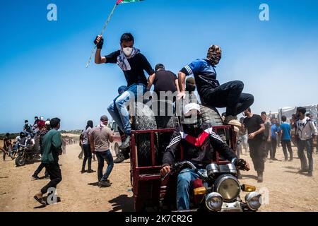 ©Michael Bunel / Le Pictorium/MAXPPP - Michael Bunel / Le Pictorium - 14/05/2018 - Palästina / Bande de Gaza / Malaka - des hommes conduisant des motos avec des pneus a bruler lors d'une Manifestation, organizee pour marquer le 70e anniversaire de la Nakba, Egalement connue sous le nom de Day of the Catastrophe en 1948, et contre les Plans des etats-Unis de transferer l'ambassade americaine a Jerusalem. 14 Mai 2018. Malaka. Bande de Gaza. Palästina. / 14/05/2018 - Palästina / Gaza-Streifen / Malaka - Männer auf Motorrädern mit brennenden Reifen bei einer Demonstration anlässlich des 70.. Jahrestreffens Stockfoto