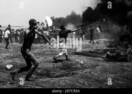 ©Michael Bunel / Le Pictorium/MAXPPP - Michael Bunel / Le Pictorium - 14/05/2018 - Palästina / Bande de Gaza / Malaka - des Palästinas verwendet des frondes pour lancer des pierres en reponse a l'Intervention des forces israeliennes lors d'une Manifestation organizee a l'occasion du 70eme anniversaire de la Nakba, Egalement connue sous le nom de Tag der Katastrophe en 1948, et contre les Plans des Etats-Unis Jerusalem. 14 Mai 2018. Malaka. Bande de Gaza. Palästina. / 14/05/2018 - Palästina / Gaza-Streifen / Malaka - Palästinenser werfen als Reaktion auf das Einziehen der israelischen Streitkräfte mit Schleuderschüssen Steine Stockfoto