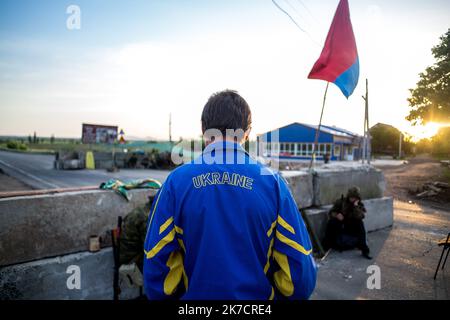 ©Michael Bunel / Le Pictorium/MAXPPP - Michael Bunel / Le Pictorium - 20/05/2014 - Ukraine / Donbass / slaviansk - UN civil avec une veste ou il est ecrit ukraine parle avec les soldats separatistes a l'un des Check-Point aux abords de Semenivka. 20 Mai 2014. Ukraine. / 20/05/2014 - Ukraine / Donbass / slawiansk - Ein Zivilist mit ukrainischer Jacke spricht an einem der Kontrollpunkte am Stadtrand von Semeniwka mit separatistischen Soldaten. 20.Mai 2014. Ukraine. Stockfoto