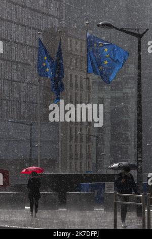 ©Nicolas Landemard / Le Pictorium/MAXPPP - Nicolas Landemard / Le Pictorium - 16/5/2021 - Belgique / Bruxelles / Bruxelles - des passants sous une pluie battante marchent a proximitte des drapeaux europeens du rond Point Schumann. / 16/5/2021 - Belgien / Brüssel / Brüssel - Passanten im strömenden Regen wandern in der Nähe der europäischen Flaggen des Schumann-Kreisel. Stockfoto