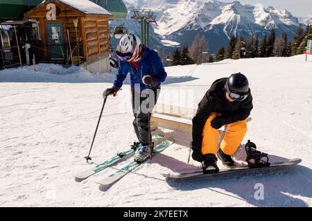 Skifahrer und Snowboarder bereiten sich im sonnigen Skigebiet vor