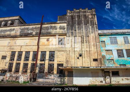 Verlassene und verfallene Fabrik mit Ziegelkamin an sonnigen Tagen Stockfoto