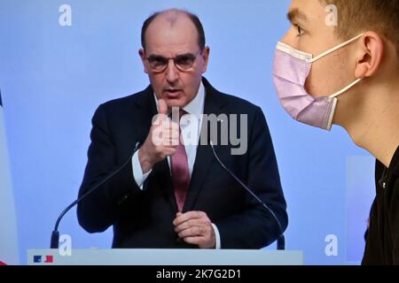 ©PHOTOPQR/L'EST REPUBLICAIN/ALEXANDRE MARCHI ; NANCY ; 27/12/2021 ; SANTE - POLITIQUE - OMICRON - EPIDEMIOLOGIE COVID 19 - CORONAVIRUS - CONFERENCE DE PRESSE PM - 5EME VAGUE - DOSE DE RAPPEL - JAUGE - DOSE DE RAPPEL - PASS SANITAIRE - PASS VACCINAL. Dezember 27 in Nancy 2021. Une personne, portant un masque chirurgical de Protection, regarde et écoute le Premier Ministre Jean CASTEX lors d'une conférence de Presse télévisée à la Suite du conseil de défense sanitaire alors qu'une nouvelle vague de contaminations déferle sur la France et dans le monde entier avec le variant Omicron. FOTO Alexandre MAR Stockfoto