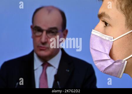 ©PHOTOPQR/L'EST REPUBLICAIN/ALEXANDRE MARCHI ; NANCY ; 27/12/2021 ; SANTE - POLITIQUE - OMICRON - EPIDEMIOLOGIE COVID 19 - CORONAVIRUS - CONFERENCE DE PRESSE PM - 5EME VAGUE - DOSE DE RAPPEL - JAUGE - DOSE DE RAPPEL - PASS SANITAIRE - PASS VACCINAL. Dezember 27 in Nancy 2021. Une personne, portant un masque chirurgical de Protection, regarde et écoute le Premier Ministre Jean CASTEX lors d'une conférence de Presse télévisée à la Suite du conseil de défense sanitaire alors qu'une nouvelle vague de contaminations déferle sur la France et dans le monde entier avec le variant Omicron. FOTO Alexandre MAR Stockfoto