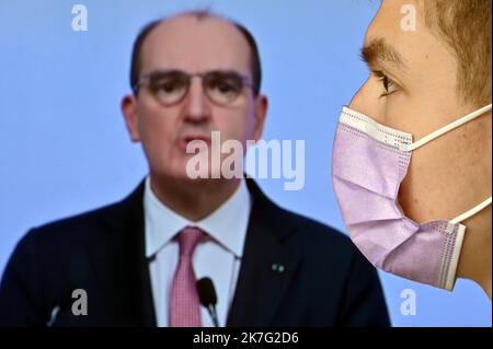 ©PHOTOPQR/L'EST REPUBLICAIN/ALEXANDRE MARCHI ; NANCY ; 27/12/2021 ; SANTE - POLITIQUE - OMICRON - EPIDEMIOLOGIE COVID 19 - CORONAVIRUS - CONFERENCE DE PRESSE PM - 5EME VAGUE - DOSE DE RAPPEL - JAUGE - DOSE DE RAPPEL - PASS SANITAIRE - PASS VACCINAL. Dezember 27 in Nancy 2021. Une personne, portant un masque chirurgical de Protection, regarde et écoute le Premier Ministre Jean CASTEX lors d'une conférence de Presse télévisée à la Suite du conseil de défense sanitaire alors qu'une nouvelle vague de contaminations déferle sur la France et dans le monde entier avec le variant Omicron. FOTO Alexandre MAR Stockfoto