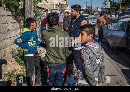 ©Christophe Petit Tesson/MAXPPP - 23/11/2021 ; MOSUL ; IRAK - UN intervenant de l'Association EliseCare parle a des enfants des rues vivant de mendicite et de vente de bouteilles d'Eau ou de chewing gum dans la rue. La ville de Mossoul, Liberee de l'Etat Islamique en Juillet 2017, a subi d'importantes destructions urbaines et se releve Petit a Petit avec l'aide de projeets internationaux sous l'egide de l'UNESCO. Straßenkinder betteln auf einer Straße in der Altstadt von Mosul, die gerade renoviert wird. Die Stadt Mosul, die im Juli 2017 vom Islamischen Staat befreit wurde, hat erhebliche städtische Schäden erlitten Stockfoto