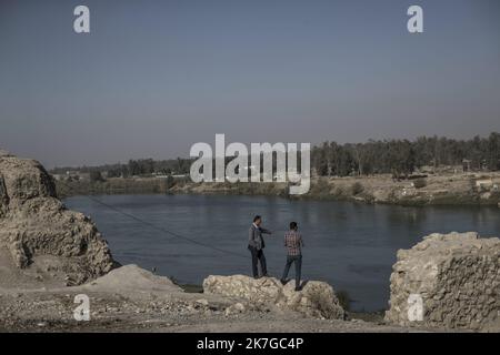 ©Christophe Petit Tesson/MAXPPP - 23/11/2021 ; MOSUL ; IRAK - des hommes discutent sur les bords du fleuve Tigre. La ville de Mossoul, Liberee de l'Etat Islamique en Juillet 2017, a subi d'importantes destructions urbaines et se releve Petit a Petit avec l'aide de projeets internationaux sous l'egide de l'UNESCO. Zwei Männer diskutieren am Ufer des Tigris in der Altstadt von Mosul, die gerade renoviert wird. Die Stadt Mosul, die im Juli 2017 vom Islamischen Staat befreit wurde, hat erhebliche städtische Zerstörungen erlitten und erholt sich allmählich mit der internationalen Initiative ‚ÄúRevive The Spirit of M Stockfoto