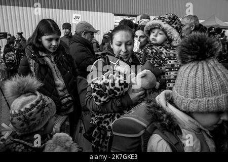 ©Michael Bunel / Le Pictorium/MAXPPP - Mlyny 03/03/2022 Michael Bunel / Le Pictorium - 3/3/2022 - Pologne / Mlyny - Devant le Centre Commercial de Mlyny transforme en Centre d'accueil temporaire, des femmes et enfants attendent de monter dans des Bus qui les conduiront vers differentes destinations en europe. Selon l'ONU, depuis le Debut de l'Invasion de l'Ukraine par l'armee Russe, pres d'un million de personnes auraient fuit le pays. 3. märz 2022. Mlyny. Pologne. / 3/3/2022 - Polen / Mlyny - vor Mlynys Einkaufszentrum, das in ein provisorisches Empfangszentrum umgewandelt wurde, Frauen und Kinder Stockfoto