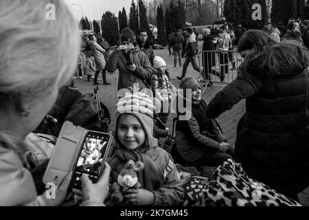 ©Michael Bunel / Le Pictorium/MAXPPP - Mlyny 03/03/2022 Michael Bunel / Le Pictorium - 3/3/2022 - Pologne / Mlyny - Devant le Centre Commercial de Mlyny transforme en Centre d'accueil temporaire, des femmes et enfants attendent de monter dans des Bus qui les conduiront vers differentes destinations en europe. Selon l'ONU, depuis le Debut de l'Invasion de l'Ukraine par l'armee Russe, pres d'un million de personnes auraient fuit le pays. 3. märz 2022. Mlyny. Pologne. / 3/3/2022 - Polen / Mlyny - vor Mlynys Einkaufszentrum, das in ein provisorisches Empfangszentrum umgewandelt wurde, Frauen und Kinder Stockfoto