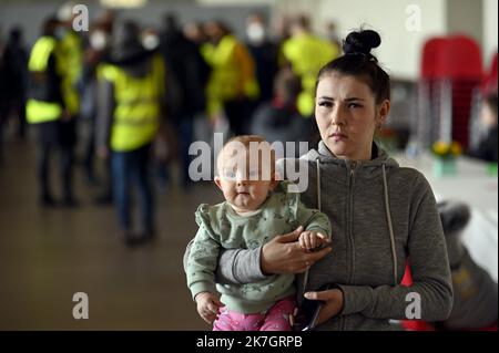 ©PHOTOPQR/L'EST REPUBLICAIN/ALEXANDRE MARCHI ; NANCY ; 19/03/2022 ; GUERRE EN UKRAINE - UNION EUROPEENNE - EXODE DES REFUGIES UKRAINIENS - ACCUEIL EN FRANKREICH - KRIEG - FLÜCHTLINGE. Nancy, 19. märz 2022. Une femme avec son enfant dans les bras, dans la grande salle de Gentilly, après l'arrivée d'un Bus avec 100 réfugiés de guerre ukrainiens, prinicpalement des femmes avec des enftans, ayant transités par Lublin (Pologne) avant d'arriver à Nancy. FOTO Alexandre MARCHI. - Frankreich 19. März 2022 Gentilly - Ankunft eines Busses mit 100 ukrainischen Kriegsflüchtlingen Stockfoto