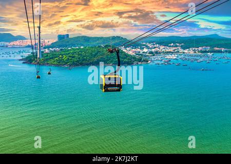 Blick auf die längste Seilbahnfahrt der Welt, Phu Quoc Insel, Vietnam, Sonnenuntergang Himmel. Unten ist Seestücke mit tropischen Inseln und Booten. Stockfoto