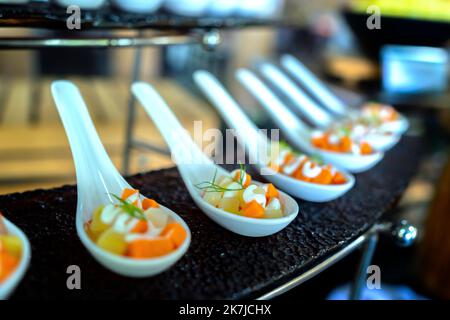 Salat, gekochtes Gemüse mit Eiern, Wassermelone, Drachenfrucht mit Mayonnaise garnieren Sie in einem Teller oder Löffel auf dem Tisch. Horizontal Stockfoto