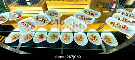 Salat, gekochtes Gemüse mit Eiern, Wassermelone, Drachenfrucht mit Mayonnaise garnieren Sie in einem Teller oder Löffel auf dem Tisch. Horizontal Stockfoto