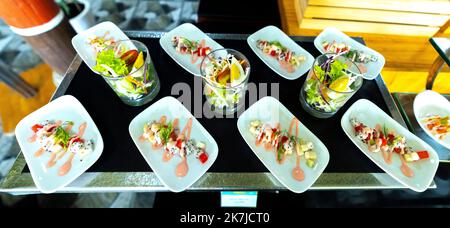 Salat, gekochtes Gemüse mit Eiern, Wassermelone, Drachenfrucht mit Mayonnaise garnieren Sie in einem Teller oder Löffel auf dem Tisch. Horizontal Stockfoto