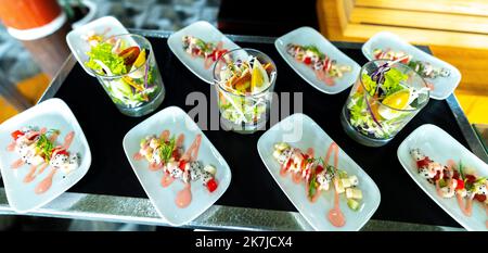 Salat, gekochtes Gemüse mit Eiern, Wassermelone, Drachenfrucht mit Mayonnaise garnieren Sie in einem Teller oder Löffel auf dem Tisch. Horizontal Stockfoto