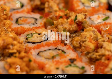 Eine Reihe verschiedener Rollentypen in einer Schachtel. Blick von oben auf verschiedene Portionen vegetarischer und Fischbrötchen. Nahaufnahme, selektiver Fokus. Stockfoto