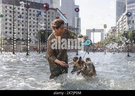 ©PHOTOPQR/LE PARISIEN/olivier corsan ; La-Defense ; 13/07/2022 ; La Défense, 92 Frankreich, le 13 Juillet 2022. Danle bassin Takis au bout de l'Esplanade de la Défense des Franciliens, comme Farida et sa chienne Perle (sur la photo) se raffraichissent alors que les températures sont très élevées et que la France connait un épisode de canicule. Les animaux souffrent aussi de la chaleur. Foto : LP / Olivier Corsan Hitzewelle in Paris am 13. Juli 2022 Stockfoto