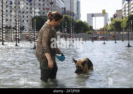 ©PHOTOPQR/LE PARISIEN/olivier corsan ; La-Defense ; 13/07/2022 ; La Défense, 92 Frankreich, le 13 Juillet 2022. Danle bassin Takis au bout de l'Esplanade de la Défense des Franciliens, comme Farida et sa chienne Perle (sur la photo) se raffraichissent alors que les températures sont très élevées et que la France connait un épisode de canicule. Les animaux souffrent aussi de la chaleur. Foto : LP / Olivier Corsan Hitzewelle in Paris am 13. Juli 2022 Stockfoto