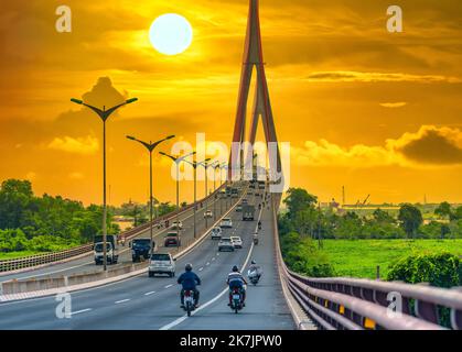 Starker Verkehr auf der Can Tho Brücke bei Sonnenuntergang. Die Can Tho-Brücke ist eine berühmte Brücke im mekong-Delta, Vietnam. Stockfoto