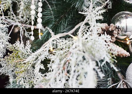 Weihnachtsschmuck auf dem Weihnachtsbaum, Kugeln und Zapfen, Papierperlen. Vorderansicht. Stockfoto