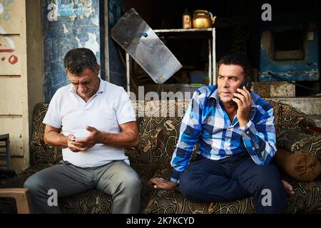 ©Thibault Savary / Le Pictorium/MAXPPP - Erbil 09/10/2019 Thibault Savary / Le Pictorium - 09/10/2019 - Irak / Kurdistan / Erbil - Deux hommes profitent d'un chai en fin de journee en telephonant, a Erbil Kurdistan Irakien. / 09/10/2019 - Irak / Kurdistan / Erbil - zwei Männer genießen einen Tee, während sie ihre Smartphones benutzen. Stockfoto