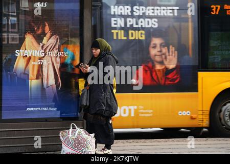 ©Thibault Savary / Le Pictorium/MAXPPP - Kopenhagen 07/10/2022 Thibault Savary / Le Pictorium - 7/10/2022 - Danemark / Kopenhagen - Une femme de confession Musulmane devant la nouvelle affiche de la compagnie eyrienne Scandinavian Airlines SAS a Kopenhagen. UN Bus de la compagnie DOT passe derriere avec le Slogan 'on a Garde une place pour toi'. / 7/10/2022 - Dänemark / Kopenhagen - Eine muslimische Frau vor der neuen Scandinavian Airlines SAS Werbekampagne in Kopenhagen. Dahinter ein Bus der Firma DOT mit der Behauptung: 'Wir haben dir einen Platz gerettet'. Stockfoto