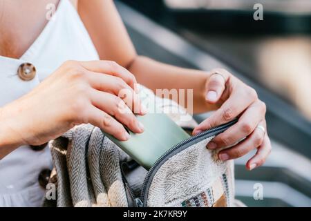 Von oben anonyme Frau, die am sonnigen Tag auf der Straße in Barcelona, Spanien, Handy aus dem Rucksack nimmt Stockfoto