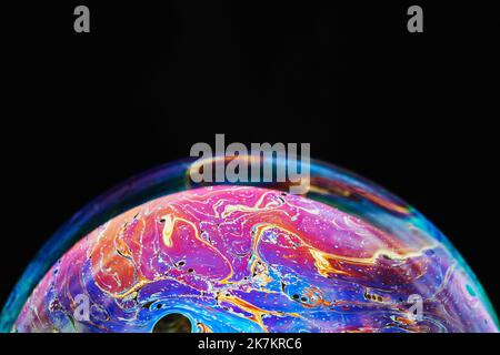 Virtual Reality Raum mit abstrakten multicolor psychedelischen Planeten. Nahaufnahme Seifenblase wie ein außerirdischer Planet auf schwarzem Hintergrund Stockfoto