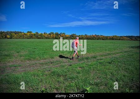 Seniorenkind, der auf dem Weg über die Wiese wandert Stockfoto