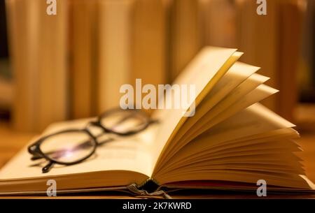 Berlin, Deutschland. 17. Oktober 2022. Eine Lesebrille liegt auf einem offenen Papierbuch. Quelle: Monika Skolimowska/dpa/Alamy Live News Stockfoto