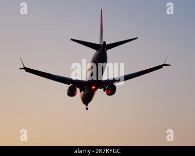 Richmond, British Columbia, Kanada. 16. Oktober 2022. Ein Lynx Air Boeing 737 MAX 8 Jetliner (C-FULH) landet in der Dämmerung aufgrund von Waldbränden im rauchigen Dunst am Vancouver International Airport. (Bild: © Bayne Stanley/ZUMA Press Wire) Stockfoto