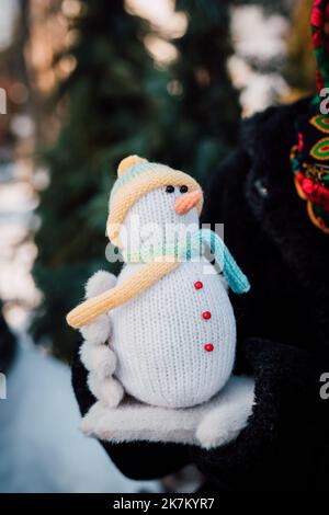 Dekorativ gestrickter Schneemann in Damenhänden von Hand gefertigt Stockfoto