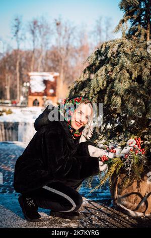 Schönes Mädchen in einem ukrainischen nationalen Schal im Winter auf der Straße Stockfoto