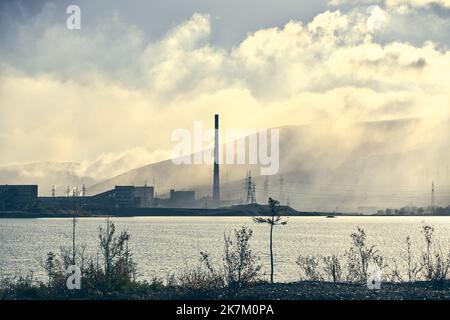 Industrielandschaft mit starker Verschmutzung durch eine große Fabrik. Rohre auf dem Gebiet der Anlage. Stockfoto