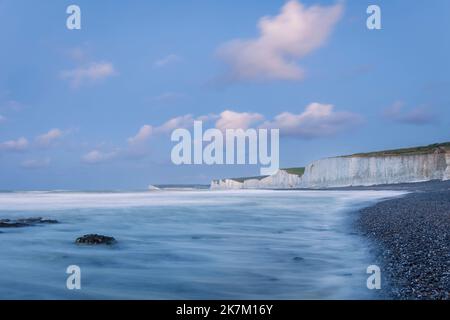 Die morgendliche blaue Stunde am Strand von Birling Gap mit Wolken über den Klippen der Seven Sisters Stockfoto