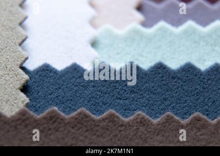Eine Palette aus weichem Velours-Stoff in verschiedenen Farben für Möbelpolster als Hintergrund-Nahaufnahme, Modestoff für Backdrops Stockfoto