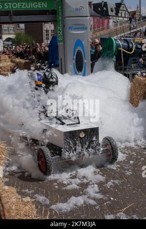 Sint Niklaas, Belgien, 05. Mai 2019, zwei Jungs fahren einen maßgefertigten Go-Kart während eines Seifenkastenrennens durch einen Berg aus Schaum Stockfoto