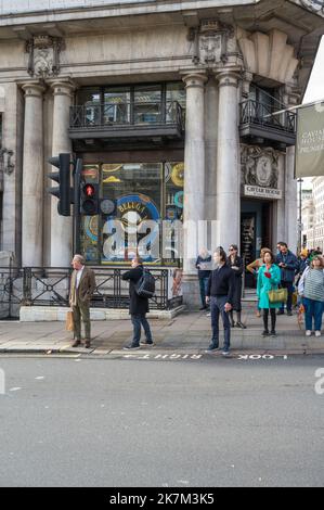 Fußgänger warten darauf, die Straße vor dem Caviar House & Prunier an der Kreuzung von St James's Street und Piccadilly zu überqueren. London, England, Großbritannien Stockfoto