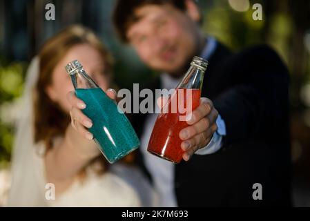 Nahaufnahme von drei Glasflaschen mit kalten Orangensaft, rotem und grünem Saft, Cocktailgetränken mit Chiasamen auf zerkleinertem Eis im Einzelhandel, Seitenansicht in niedriger Winkel Stockfoto