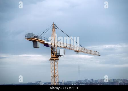 Krane auf der Baustelle. Große Baustelle, Krane. Turmdrehkrane in Aktion auf blauem Himmel Hintergrund. Wohnungssanierungskonzept. Selektiver FOC Stockfoto