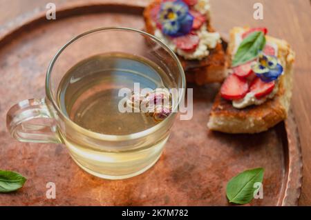 Strawberry Toast Brioche mit Frischkäse mit Blumen verziert und Basilikum flach legen aus der Nähe Stockfoto